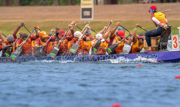 Dragon boat crew paddling in race