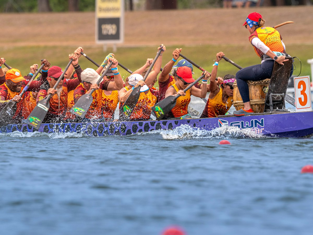 Dragon boat crew paddling hard in a race